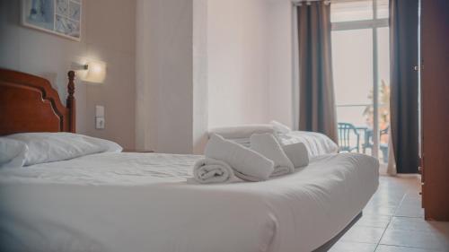 a hotel room with a bed with towels on it at Barraca Suites in Valencia