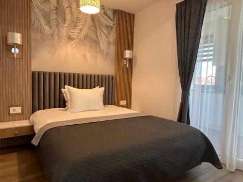 a bedroom with a large bed with a window at Coquette Studio Central in Oradea