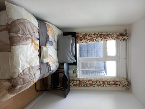 a bedroom with a bed and a window at Beautiful 5-Bed House in Dagenham newly Renovated in Dagenham