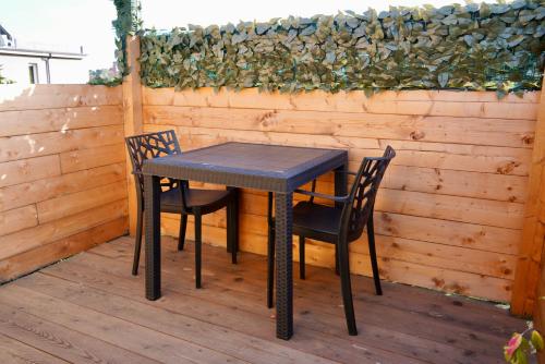 un tavolo nero e due sedie su una terrazza di Starsbox con piscina e idromassaggio a Celle Ligure