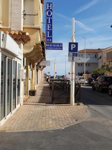 un coin rue avec un panneau de stationnement sur un bâtiment dans l'établissement Hotel De La Plage, à Valras-Plage