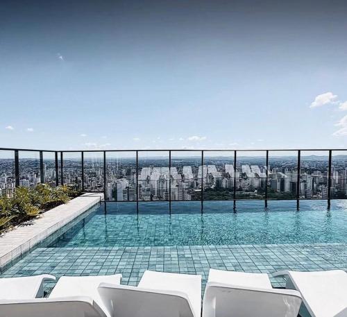 a swimming pool with a view of a city at Lindo flat em prédio luxuoso - Excelente localização in Goiânia