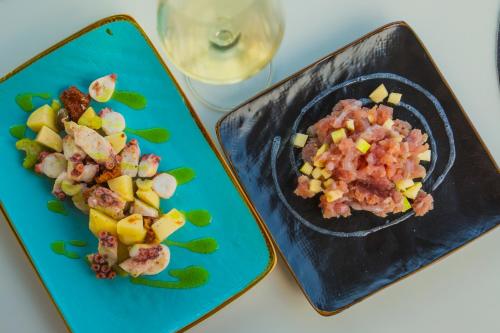 two plates of food with vegetables and a glass of wine at Camping Italia Lido in Castelletto sopra Ticino