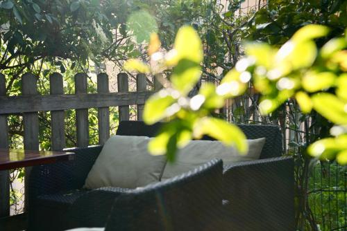 a bench with a pillow on it in front of a fence at StarsBox jacuzzi privata e piscina vista mare in Celle Ligure