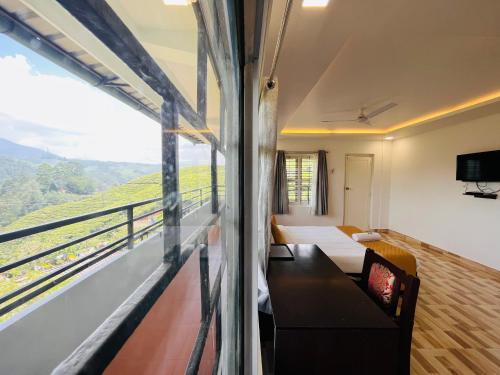 a room with a couch and a window with a view at 5 Bedroom in Tea Plantation in Munnar