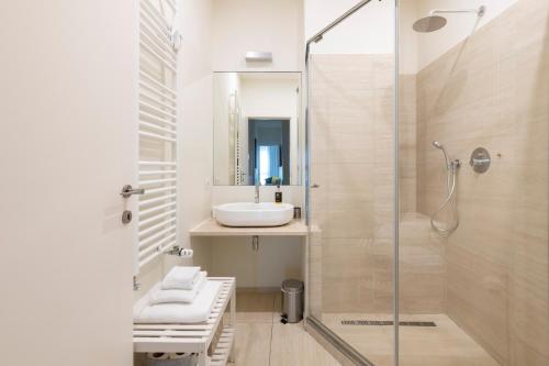 a bathroom with a sink and a glass shower at Heart Milan Apartments San Sepolcro Duomo in Milan