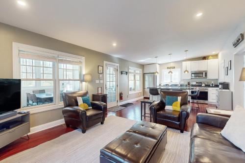 a living room with a couch and chairs and a kitchen at Rise n Shine in Saugatuck