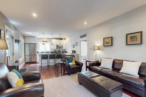 a living room with leather furniture and a kitchen at Rise n Shine in Saugatuck