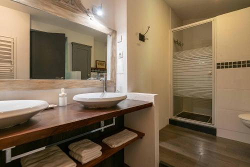a bathroom with two sinks and a large mirror at La Longère Bordeaux gite de charme prés de Bordeaux in Cénac