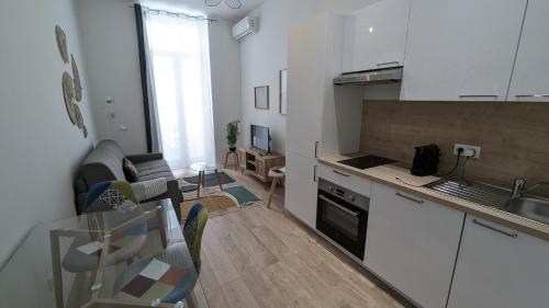 une cuisine et un salon avec une table et des chaises dans l'établissement COMBOUL, à Nice