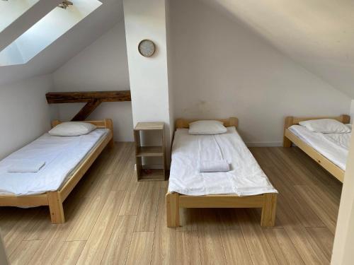 Zimmer mit 2 Betten und einer Uhr an der Wand in der Unterkunft Pini Apartments & Rooms Old Town in Krakau