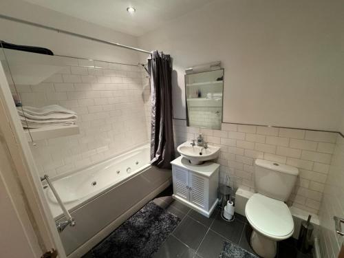 a bathroom with a toilet and a sink and a tub at City Centre Apartment Liverpool in Liverpool
