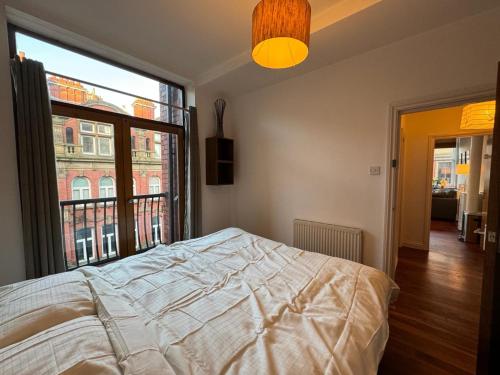 a bedroom with a bed and a large window at City Centre Apartment Liverpool in Liverpool
