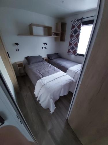 ein Schlafzimmer mit zwei Betten und einem Fenster in der Unterkunft BUNGALOW - Cap Ferret in Lège-Cap-Ferret