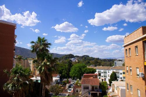 a view of a city with palm trees and buildings at Stylish and comfortable one bedroom with sea view in Torremolinos