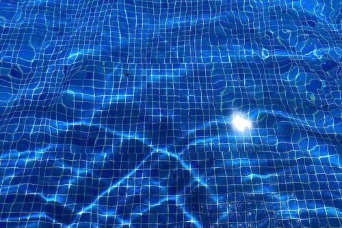 a pool of blue water with lights in it at Stylish and comfortable one bedroom with sea view in Torremolinos