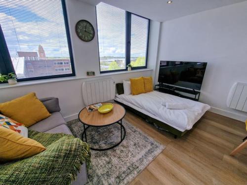 - un salon avec un canapé et une table dans l'établissement Stunning Old Trafford Apartment, à Manchester