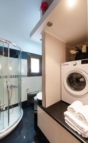 a bathroom with a washing machine and a shower at Elvira’s House in Lefkada