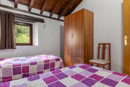 a bedroom with a bed and a cabinet and a window at La Plazuca Cerrucao in Selaya