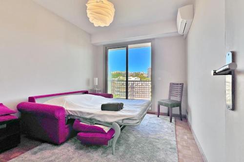 Cette chambre comprend un lit et un canapé violet. dans l'établissement La Baia Dei Ange, à Nice