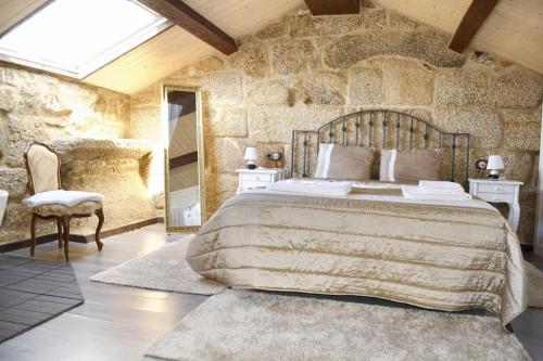 sypialnia z dużym łóżkiem i kamienną ścianą w obiekcie 4 bedrooms house with sea view enclosed garden and wifi at Cambados Pontevedra 1 km away from the beach w mieście Cambados