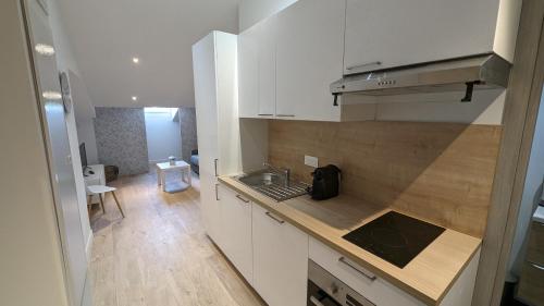 une cuisine avec des armoires blanches et un comptoir dans l'établissement COMBOUL, à Nice