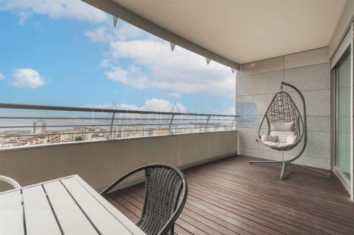 balcón con hamaca, mesa y sillas en Torre Mizar 11, en Lido di Jesolo