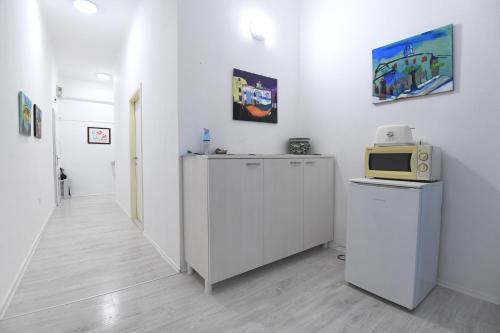 a white room with a microwave and a refrigerator at Green lighthouse rooms in Zadar