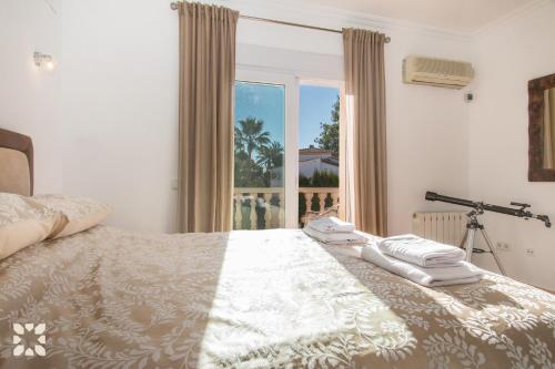 1 dormitorio con 1 cama con 2 toallas en Villa Nasau by Abahana Villas, en Moraira