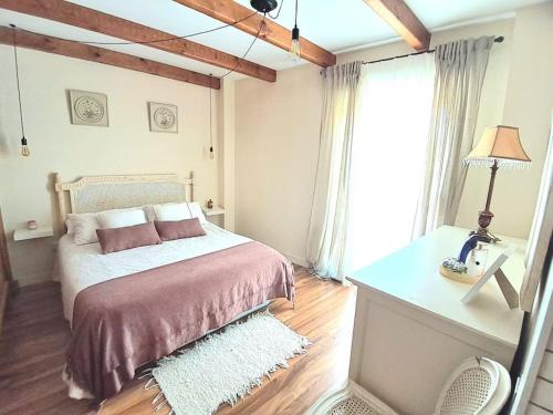 1 dormitorio con 1 cama y 1 mesa con lámpara en Encantador Apartamento en Vejer, en Vejer de la Frontera
