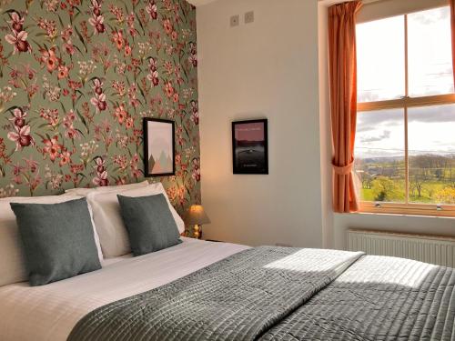 a bedroom with a bed with a floral wallpaper at Laurel Bank House in Penrith