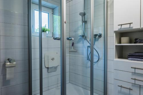 um chuveiro com uma porta de vidro na casa de banho em Ferienhaus am Staufeneck em Piding
