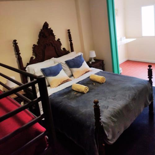 a bedroom with a large bed with pillows on it at Liberdade Home Royal direito in Braga