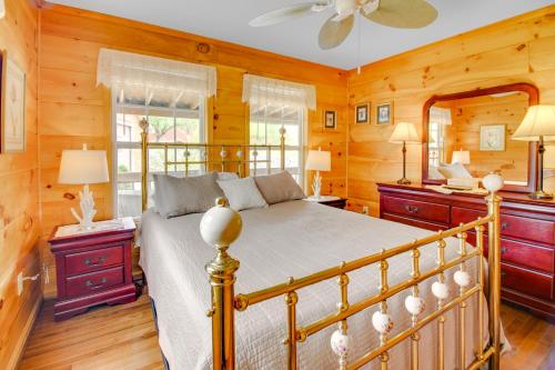1 dormitorio con 1 cama en una habitación con paredes de madera en Cozy Cabin with Grill and Fire Pit By Dale Hollow Lake en Frogue