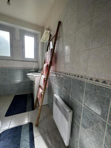 La salle de bains est pourvue d'un sèche-serviettes et d'un lavabo. dans l'établissement Maison de campagne 5 min A20, à Brive-la-Gaillarde