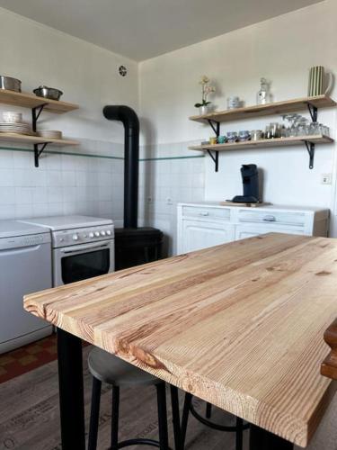 - une cuisine avec une table en bois et une cuisinière dans l'établissement Maison de campagne 5 min A20, à Brive-la-Gaillarde