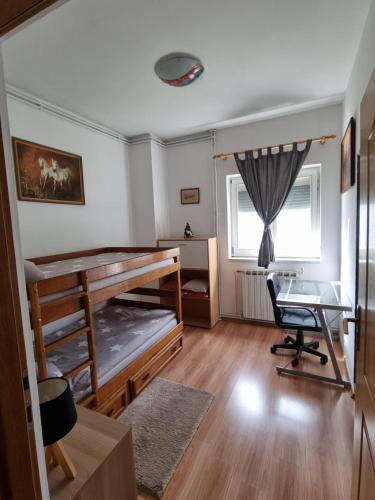 a bedroom with a bunk bed and a desk at Holiday Home Baotic in Velika Mlaka