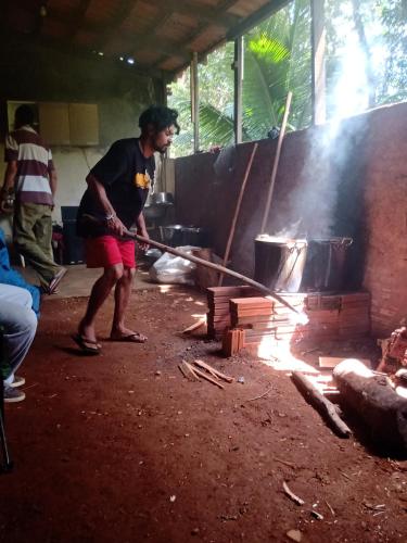 een man smeedt hout op een vuur bij Laroyê hostel in Pirenópolis