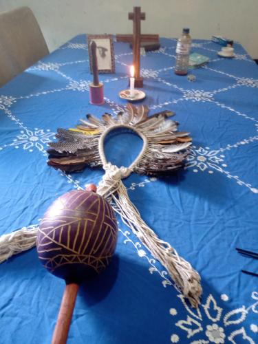een tafel met een blauwe tafeldoek met een kruis en kaarsen bij Laroyê hostel in Pirenópolis