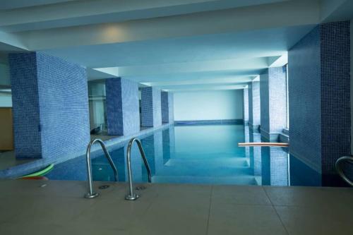 a swimming pool with blue tile walls and blue tiles at Kitengule Apartment 001 in Dar es Salaam