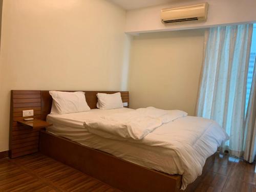 a bedroom with a large bed with a window at Kitengule Apartment 001 in Dar es Salaam