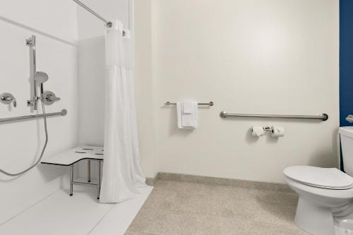a white bathroom with a toilet and a shower at Spark by Hilton Commerce, GA in Commerce