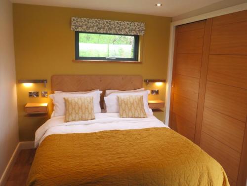 a bedroom with a large bed and a window at The Lodges at Thornbrook in Ingleton 