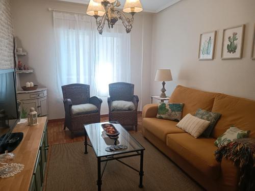 a living room with a couch and a table at Como una casa de campo en la ciudad, con patio -Parking gratis in Gijón