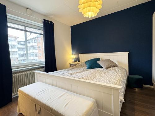 1 dormitorio con cama blanca y pared azul en Nice, quiet apartment in central Karlstad, en Karlstad