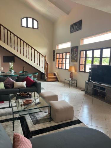 a living room with a couch and a tv at Résidence Gabrielle in São Tomé