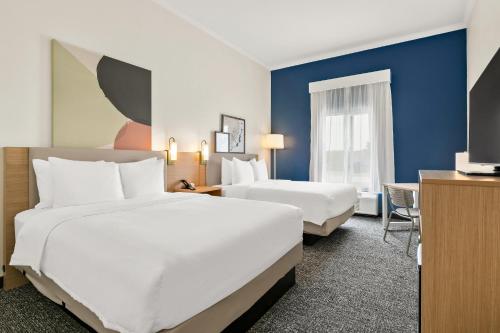 ein Hotelzimmer mit 2 Betten und einem Schreibtisch in der Unterkunft Spark by Hilton Commerce, GA in Commerce