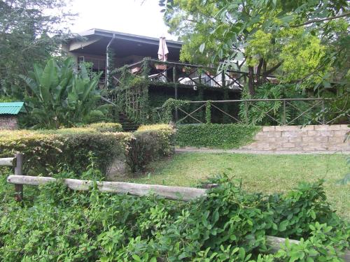 a garden with a fence and a house at Old Coach Road Guest House in Barberton