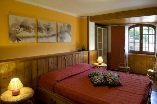 una camera con un letto con copriletto rosso di Casa Vacanze Colline di Luni a Castelnuovo di Magra