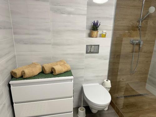 a bathroom with a toilet and a shower with towels at Piękna Góra in Giżycko